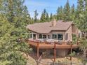 Rear exterior view showcases spacious deck with hot tub and outdoor seating area overlooking fenced area at 3726 Spring Valley Trl, Evergreen, CO 80439