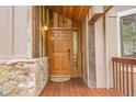 The home's entryway has a wooden door and wooden exterior and stonework for added curb appeal at 3726 Spring Valley Trl, Evergreen, CO 80439