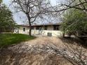Landscaped backyard shows patio doors, a small lawn, and a large rock feature at 6085 Simms St, Arvada, CO 80004