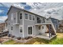 Back of the gray two-story home with a deck, patio and stairs leading to the backyard at 8459 Sweet Clover Way, Parker, CO 80134