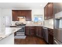 The kitchen features dark cabinets, tile backsplash, stainless steel appliances, and granite countertops at 5480 Danube St, Denver, CO 80249