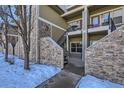 Stone exterior with stairs leading to a private patio at 5800 Tower Rd # 103, Denver, CO 80249