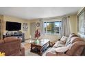 Bright living room featuring comfortable seating and a large TV at 8377 Mitze Dr, Denver, CO 80221