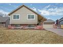 Traditional two-story home boasts an attached garage and brick accents at 7949 W Portland Ave, Littleton, CO 80128