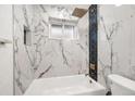 Elegant bathroom with marble tile, and a modern shower head in this serene space at 3640 Forest St, Denver, CO 80207
