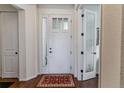 Bright entryway featuring a white front door with glass sidelights and hardwood flooring at 6948 W Jewell Dr, Lakewood, CO 80227