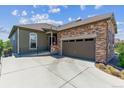 View of a single Gathering home showing the garage, front door, and manicured landscaping at 6948 W Jewell Dr, Lakewood, CO 80227