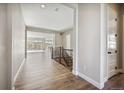Bright hallway featuring wood-style floors and staircase with wrought iron spindles, leading to a living area with scenic views at 17054 Hop Clover Ave, Parker, CO 80134