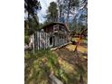 Cabin-style home with a balcony and an attached weathered shed with overgrown vegetation at 27447 Upper Cold Spg Gulch Rd, Golden, CO 80401
