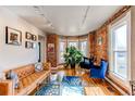 Living room with exposed brick walls, bay windows, stylish furnishings, and hardwood floors at 4337 Umatilla St, Denver, CO 80211