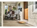 Inviting front porch featuring comfortable rocking chairs, textured brick, and a welcoming entrance at 1474 S Emerson St, Denver, CO 80210