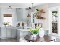 Bright kitchen featuring gray cabinetry, a farm sink, open shelving, and stylish pendant lighting at 1474 S Emerson St, Denver, CO 80210