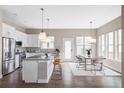 Modern kitchen with white cabinetry, granite countertops, stainless steel appliances, and island seating at 10384 E 60Th Pl, Denver, CO 80238
