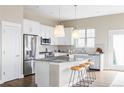 Bright kitchen with white cabinets, stainless steel appliances, granite countertops, and eat-in island at 10384 E 60Th Pl, Denver, CO 80238