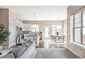 Open-concept living space featuring hardwood floors, kitchen, dining area, and lots of natural light at 10384 E 60Th Pl, Denver, CO 80238