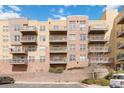 Exterior building view shows balconies, parking, and colorful architecture against a partly cloudy blue sky at 9079 E Panorama Cir # 520, Englewood, CO 80112