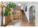 Spacious foyer with a wooden front door, hardwood floors, staircase, and arched doorway at 8007 Sunrise Cir, Frederick, CO 80516