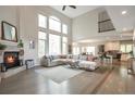 Sun-drenched living room boasts a soaring ceiling, fireplace, large windows, and open-concept design at 10773 Cougar Rdg, Lone Tree, CO 80124
