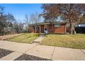 Quaint single story house with brick facade, lawn and walkway leading to the front door at 1632 Ulster St, Denver, CO 80220