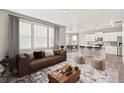 Bright and open living room featuring an open floor plan into the kitchen area at 17817 Dandy Brush Dr, Parker, CO 80134