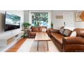 Comfortable living room with hardwood floors, leather sofas, and bright window at 3471 W Exposition Ave, Denver, CO 80219