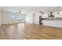 Open-concept living space with hardwood floors and a view of the modern kitchen at 42974 Colonial Trl, Elizabeth, CO 80107
