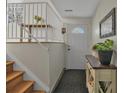 Bright foyer with hardwood stairs, stylish console table, and decorative mirror at 9120 W Bellwood Pl, Littleton, CO 80123