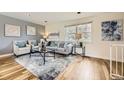 Bright living room featuring hardwood floors, modern decor, a decorative rug and large windows at 9120 W Bellwood Pl, Littleton, CO 80123