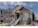 Charming two-story home featuring a stone facade and inviting front porch with painted white stairs at 4483 Fell Mist Way, Castle Rock, CO 80109