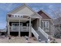 Charming two-story home featuring a stone facade and inviting front porch with painted white stairs at 4483 Fell Mist Way, Castle Rock, CO 80109