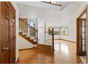 Two-story entry with hardwood floors, staircase, and views to living room at 9992 Millrock Ter, Parker, CO 80134