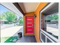 Contemporary covered entryway showcasing a vibrant red door, modern fixtures, and natural light at 5480 W Iowa Ave, Lakewood, CO 80232