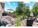 Inviting outdoor patio with comfortable seating, a built-in grill, umbrella, and lush landscaping for relaxing and entertaining at 1902 Pioneer Cir, Lafayette, CO 80026