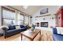 Bright living room boasting large windows, a cozy fireplace, and hardwood floors at 11666 W 74Th Way, Arvada, CO 80005