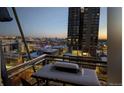 Balcony view of the city with outdoor table and grill covered in snow at 2020 Arapahoe St # 1150, Denver, CO 80205