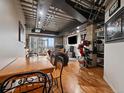 Stylish living room with exposed ceilings, wooden floors, and large windows showcasing city views at 2020 Arapahoe St # 1150, Denver, CO 80205