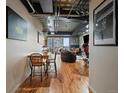 Open concept living and dining area with hardwood floors, exposed pipes and city view at 2020 Arapahoe St # 1150, Denver, CO 80205