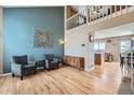 Inviting living room with high ceilings, hardwood floors, and an open layout connecting to the kitchen and dining area at 12550 W Gould Dr, Littleton, CO 80127