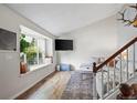 Bright living room with hardwood floors, a large window seat, and open staircase to the second floor at 8896 W Teton Cir, Littleton, CO 80128
