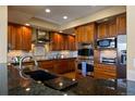 Gourmet kitchen with granite counters, stainless steel appliances, and custom cabinetry at 4373 E Phillips Pl, Centennial, CO 80122