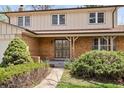 Inviting front entry with brick facade, covered porch and green shrubbery creating a warm welcome at 9004 E Floyd Ave, Denver, CO 80231