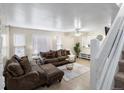 Bright living room featuring an open staircase, hardwood flooring, and a comfortable seating arrangement at 1310 S Carson Way, Aurora, CO 80012