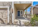 Covered front porch with charming blue front door and craftsman details on a tan home at 2229 Hyacinth Rd, Highlands Ranch, CO 80129