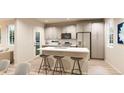 Modern kitchen boasts stainless appliances, ample counter space, and stylish bar stool seating at the island at 22343 E 38Th Pl, Aurora, CO 80019