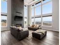 This spacious living room features an elegant fireplace with high ceiling and large windows with amazing views at 730 Edenborn Pl, Castle Rock, CO 80104
