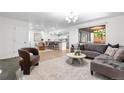 Open-concept living room flowing into a dining area, with a modern color palette and hardwood flooring at 9587 W 89Th Cir, Broomfield, CO 80021