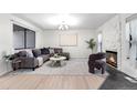 Cozy living room featuring a plush gray sectional, unique fireplace, and light wood floors at 9587 W 89Th Cir, Broomfield, CO 80021