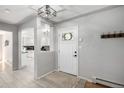 Bright entryway featuring tiled floors, coat hooks, a modern light fixture, and views into the kitchen at 13000 Willow Ln, Golden, CO 80401