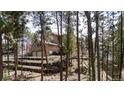 View of the home's exterior, showcasing the terraced landscaping and garage nestled in a wooded area at 19595 E Top O The Moor Dr, Monument, CO 80132