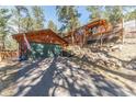 Beautiful home exterior featuring a two-car garage and hillside landscaping at 27407 Upper Cold Spg Gulch Rd, Golden, CO 80401